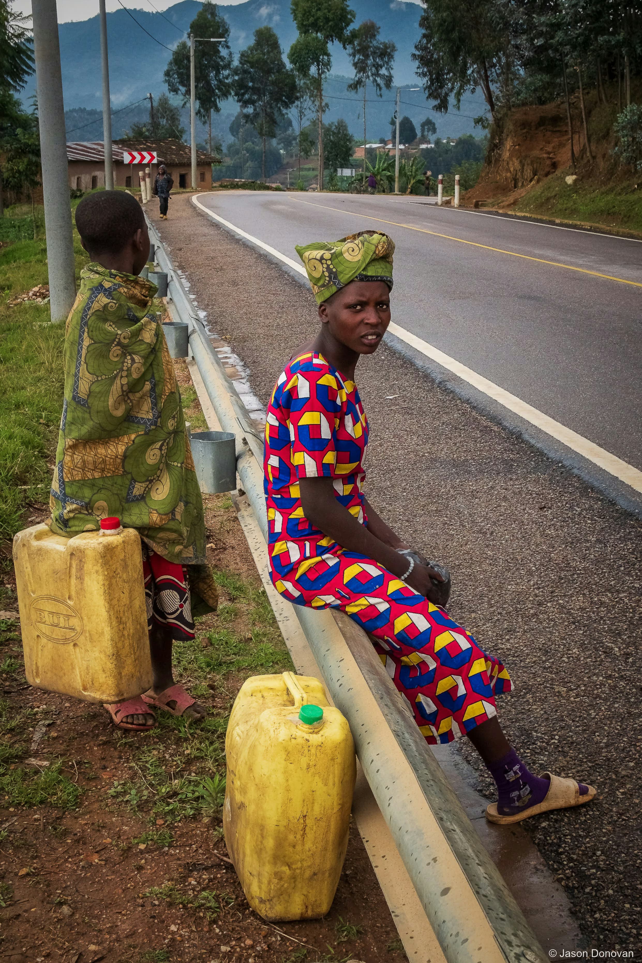 Resting with water containers Rwanda photography by Jason Donovan