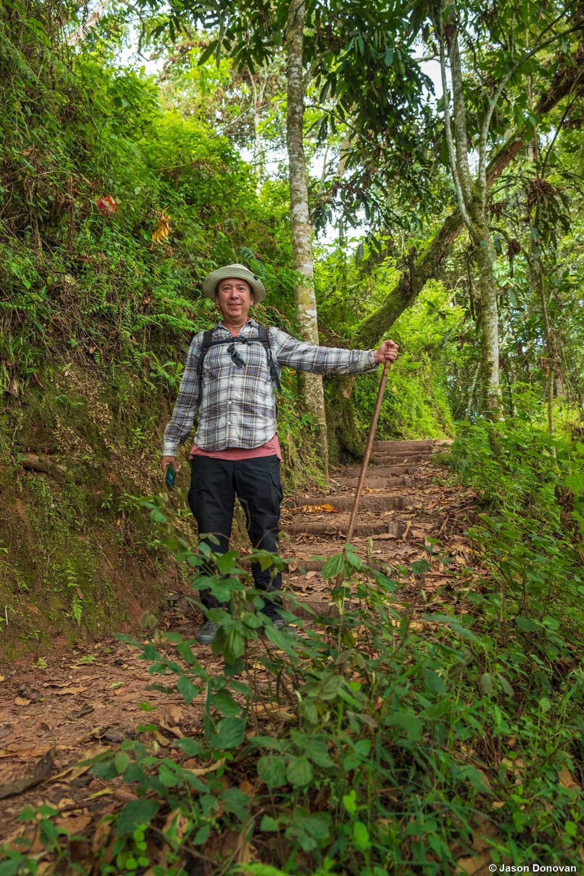 Jason on forest trail arms outstretched Volcanoes National Park Rwanda